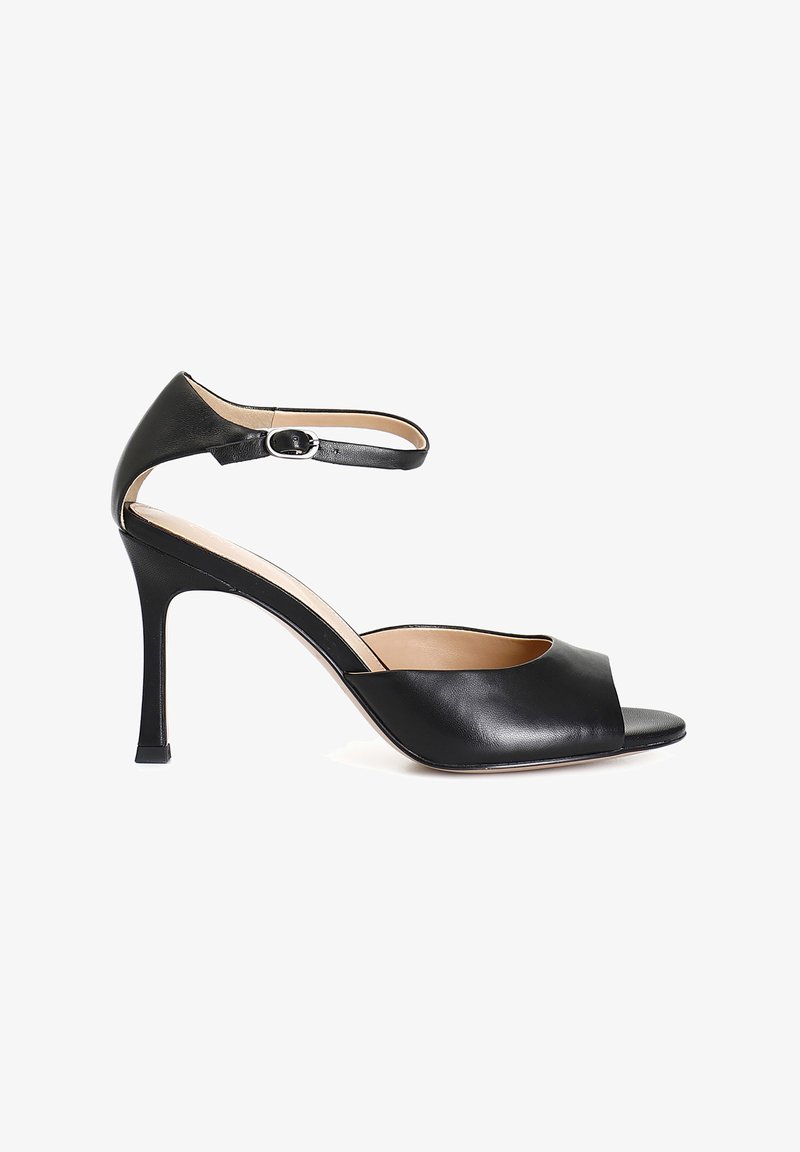 Sandal de tacón alto de cuero negro con punta abierta, correa en el tobillo y diseño elegante. Presenta una textura suave y un tacón delgado y afilado.