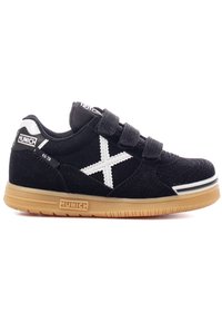 Zapatilla de velcro negra con logo "X" blanco, material de ante, suela de goma y marca en el talón y la lengua. Punta redondeada y diseño texturizado.