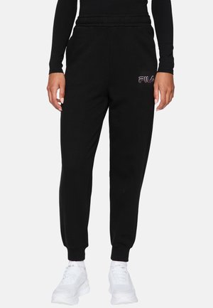 Pantaloni tuta neri in misto cotone, con vita elastica, gambe affusolate e logo FILA bianco sulla coscia sinistra.