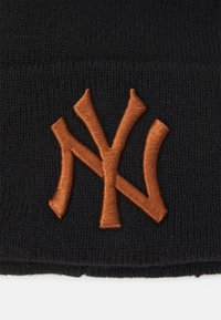 Gorro de punto negro con un logotipo bordado en naranja "NY". La tela tiene una textura con un ajuste ceñido, adecuado para usar en clima frío.