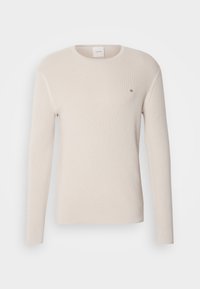 Beige long-sleeve sweater in a ribbed texture with a round neckline. Features a small black "ck" logo on the chest. Soft, lightweight fabric.
