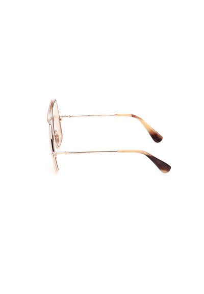 Occhiali da sole con montatura in metallo dorato e lenti trasparenti, caratterizzati da punte in acetato marrone chiaro a gradiente e aste sottili. Design rotondo, hardware minimal.
