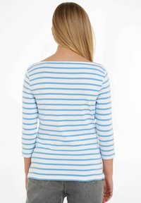 Camisa de manga larga con un patrón de rayas horizontales azules y blancas, confeccionada en tela suave, con escote barco y corte holgado.