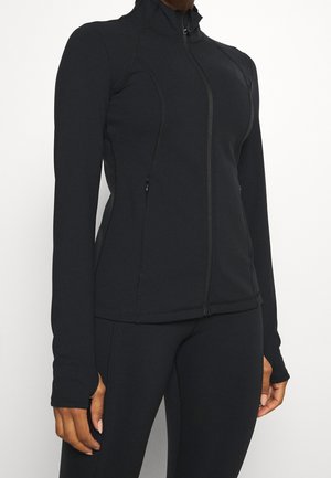 Czarna kurtka zapinana na zamek z długimi rękawami, wykonana z rozciągliwego materiału. Posiada boczne kieszenie oraz wysoki kołnierz z detalami szwów.