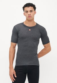 Kurzärmliges, eng anliegendes T-Shirt aus dunkelgrauem Material mit geripptem Rundhalsausschnitt. Auf der Brust befindet sich ein kleines rotes Logo. Glatte Textur.