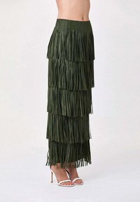 Jupe maxi à franges de couleur vert foncé avec un design superposé. Fabriquée dans un matériau texturé, elle présente une large taille et un mouvement subtil.
