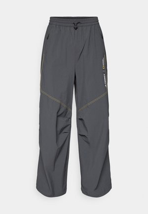 Grey outdoor pants with an elastic waistband and adjustable drawstring. Features yellow stitching and multiple zippered pockets. Lightweight fabric.