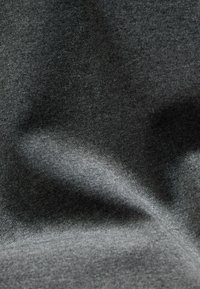 Close-up of textured dark gray fabric with soft folds creating subtle shadows and highlights.