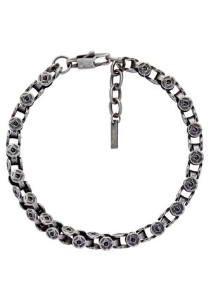 Bracelet en chaîne argentée avec des maillons floraux circulaires et une fermeture ajustable sur fond blanc.