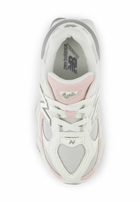 Scarpa sportiva bianca con dettagli rosa e grigi, materiali in rete e camoscio, forma arrotondata e sistema di allacciatura tradizionale. Presenta un dettaglio del logo.