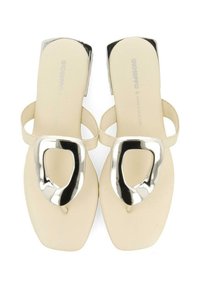 Sandalias beige con un acento geométrico plateado brillante, que cuentan con una suela plana y un diseño con tiras. Textura suave y forma moderna.