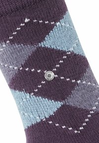 Skarpety w desenie argyle w kolorze fioletowym i jasnoniebieskim, z teksturowanym splotem, z małą srebrną metką. Widoczne misternie wykonane detalowanie ściegów.