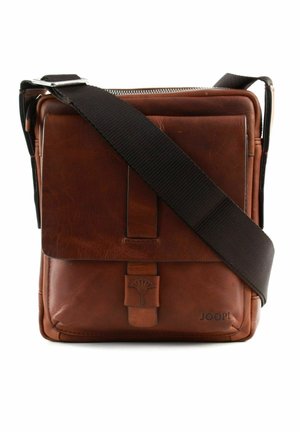 Sac à bandoulière en cuir brun avec rabat avant, logo embossé et large bandoulière en tissu brun foncé réglable, se tenant droit sur fond blanc.