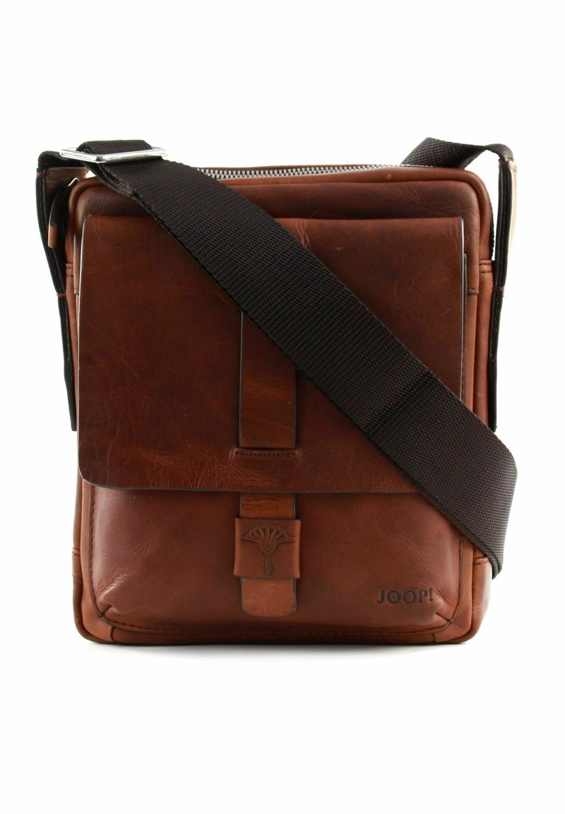 Brown leather crossbody bag with front flap, embossed logo, and wide adjustable dark brown fabric strap, standing upright on white background.