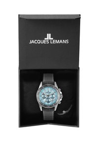 Reloj Jacques Lemans en una caja negra. Presenta una esfera azul, bisel plateado y una correa de cuero negra. Tres subesferas en la carátula.