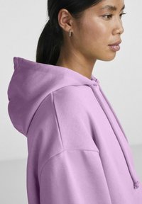 Felpa viola chiaro realizzata in morbido materiale, con cappuccio regolabile e vestibilità comoda, arricchita da dettagli di cucitura lungo le cuciture.