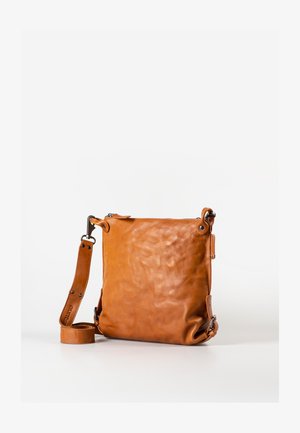 Braune Leder-Umhängetasche mit verstellbarem Riemen, Reißverschlussverschluss und Metallbeschlägen, aufrecht stehend auf einer weißen Oberfläche.
