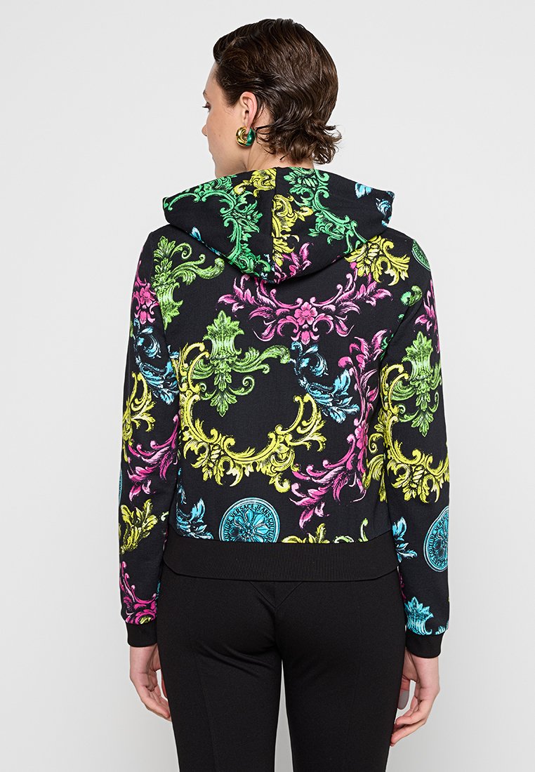 Obcisła czarna bluza z kapturem z kolorowym nadrukiem w kwiaty i medaliony, z regulowanym kapturem oraz ściągaczami na mankietach i u dołu. Wykonana z miękkiego materiału.