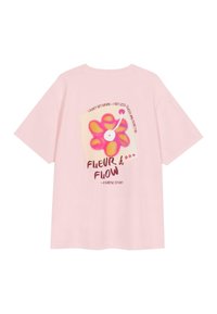T-shirt oversize rose clair en coton avec un graphique de fleurs colorées et du texte, à coupe décontractée et à manches courtes.