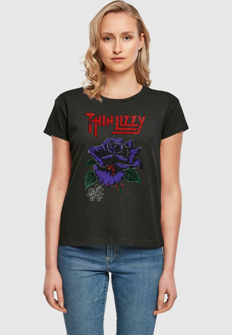 Černé bavlněné tričko s grafickým vyobrazením fialové růže a červeným textem "Thin Lizzy". Krátké rukávy, kulatý výstřih, volný střih.