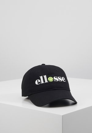 Casquette de baseball noire avec une visière incurvée, portant le logo texte blanc "ellesse" et un visage souriant vert remplaçant le "o", présentée sur une surface blanche.