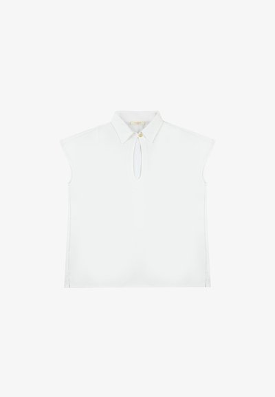 Blusa bianca senza maniche con colletto, apertura a occhio di bue sul davanti e una vestibilità leggermente rilassata. Tessuto morbido e liscio con bordi puliti.