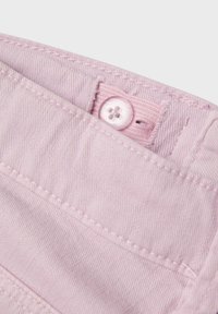 Tejido de algodón de color rosa claro con una textura suave, que cuenta con un cierre de botón y detalles de costura visibles.