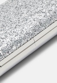 Silberne Glitzer-Clutch mit glatter Oberfläche, metallic glänzender Hardware und elegantem rechteckigen Design. Mit einer subtilen Naht-Detail versehen.