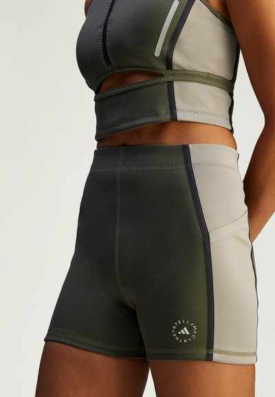 Shorts de sport en vert atténué et gris, fabriqués dans un tissu lisse et extensible. Équipés de coutures contrastées et d'un détail de logo sur l'ourlet.