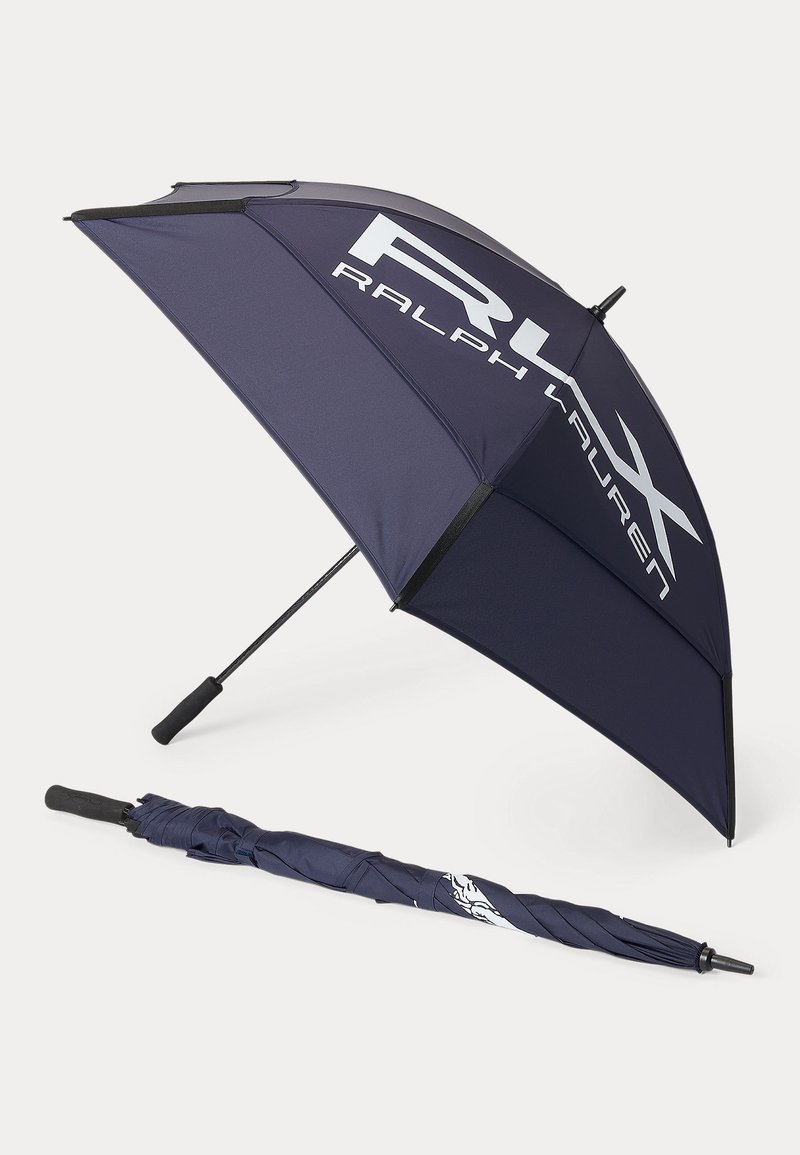 Ombrello da golf blu scuro con manico nero, uno aperto che mostra il logo bianco "RLX Ralph Lauren" e uno chiuso disteso accanto.