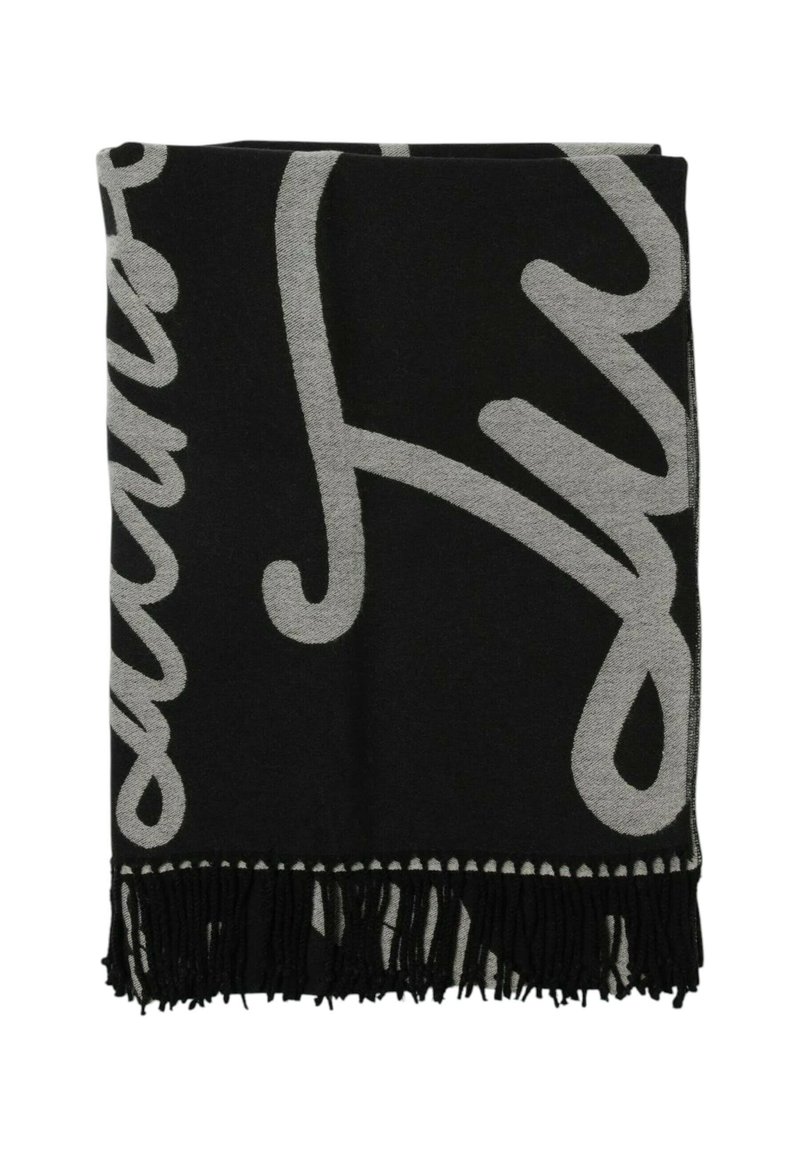 Coperta tessuta in nero e grigio con dettagli a frange, caratterizzata da un design astratto audace in un colore più chiaro su uno sfondo scuro.