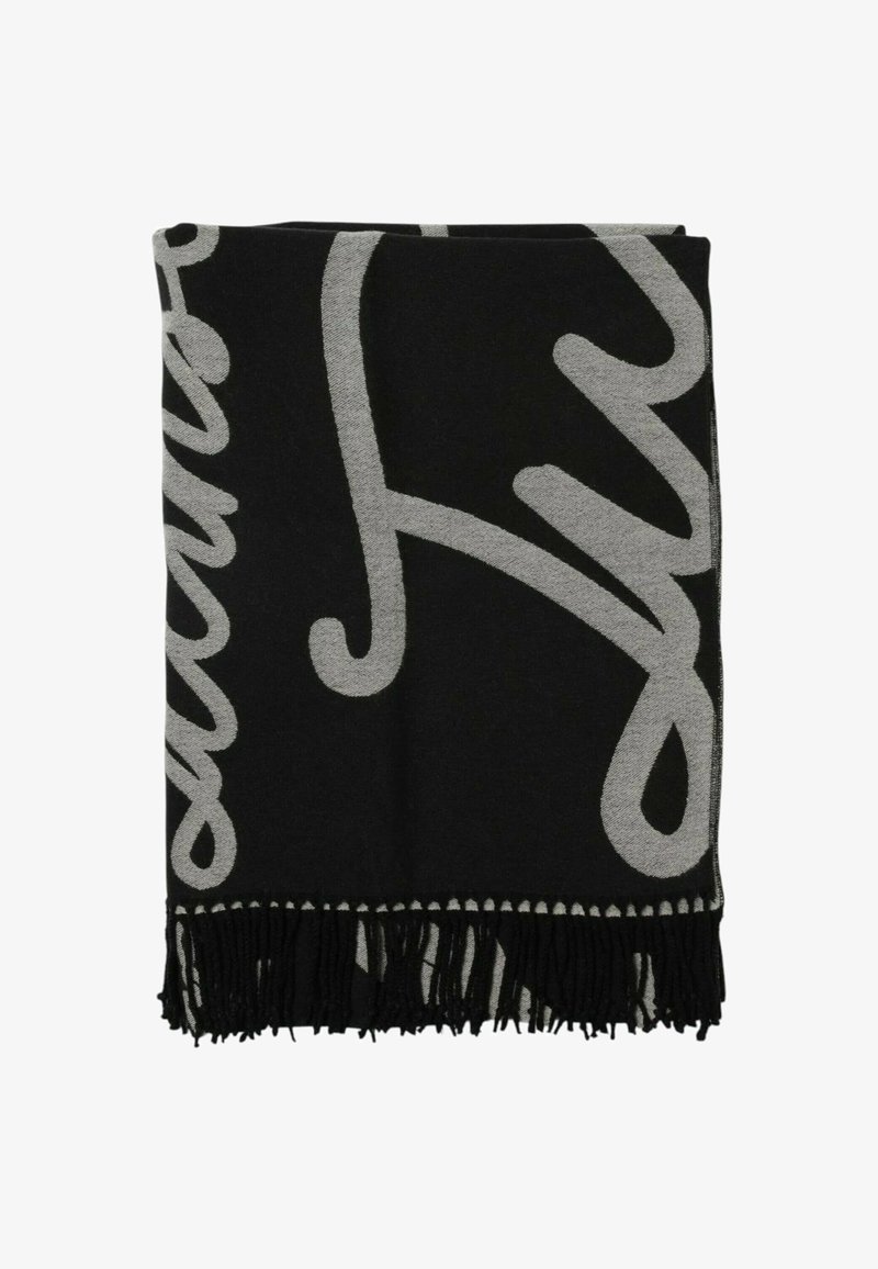 Coperta tessuta in nero e grigio con dettagli a frange, caratterizzata da un design astratto audace in un colore più chiaro su uno sfondo scuro.