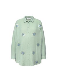 Chemise vert clair à manches longues avec col et boutons, avec plusieurs motifs d'yeux bleus brodés sur le devant et les manches.
