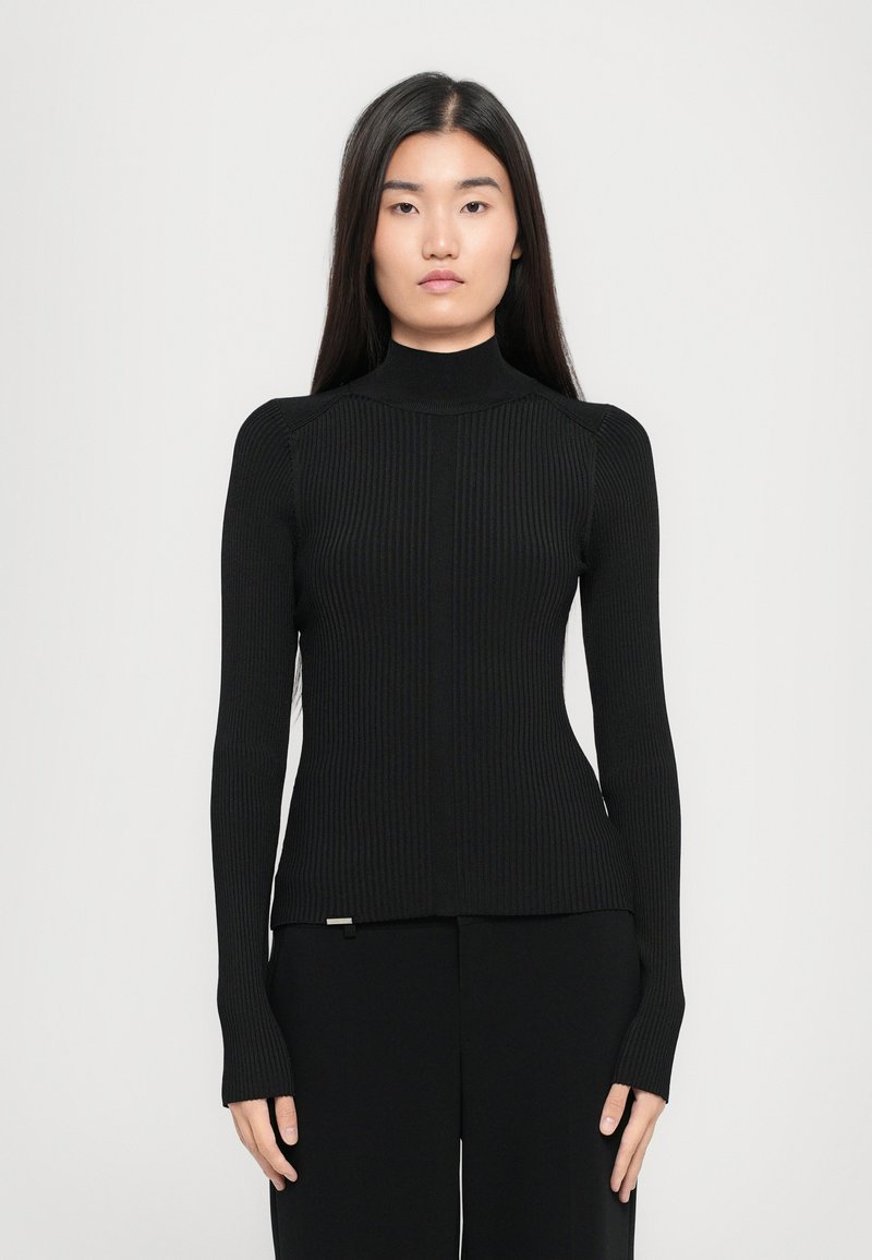 Pulover negru cu guler înalt, cu mâneci lungi, design ajustat și accente fără cusături la umeri, având un detaliu metalic subtil la tiv.