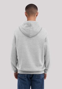 Grau Kapuzenpullover aus weichem Stoff, mit lockerer Passform und gerippten Bündchen. Ausgestattet mit einer runden Kapuze und seitlichen Eingrifftaschen.