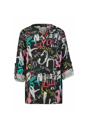 Blouse noire aux manches retroussées avec texte coloré style graffiti et formes abstraites en rouge, jaune, sarcelle, rose et blanc.
