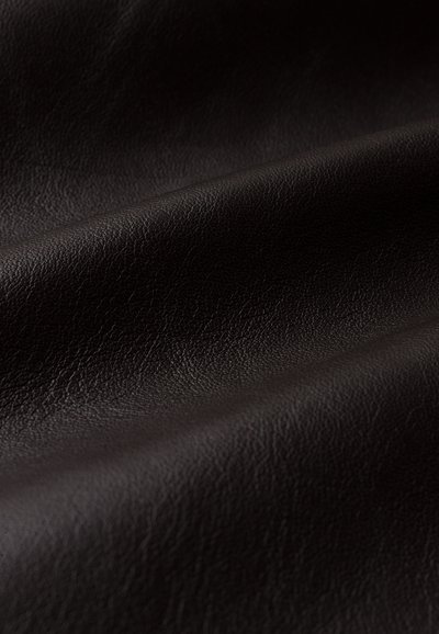 Dunkelbraunes Ledergewebe mit strukturierten Oberflächen und weichem Finish, das subtile Falten und glatte Knicke aufweist. Geeignet für Polsterungen oder Mode.