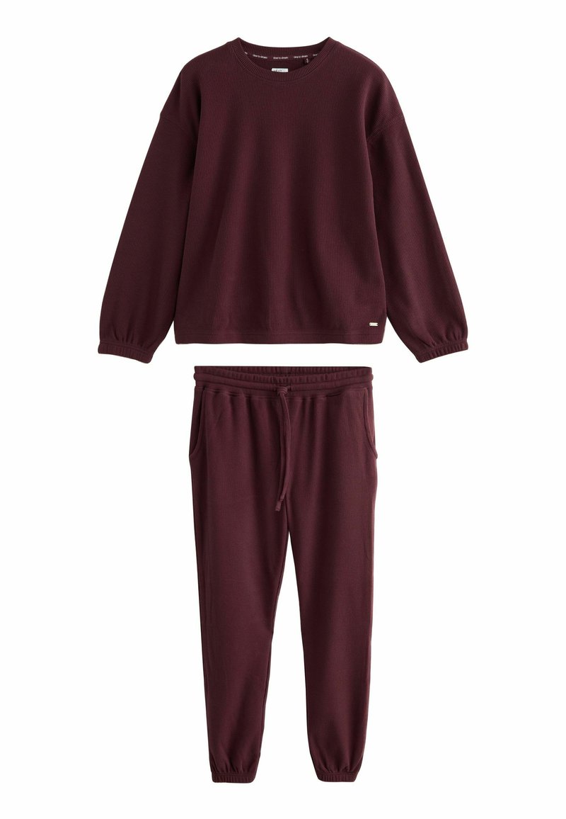 Burgundy loungewear szett, textúrált anyagból készült, amely tartalmaz egy hosszú ujjú, kerek nyakú pulóvert és elasztikus derekú, zsinórral ellátott nadrágot.