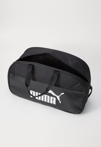 Borsa a duffel nera realizzata in materiale resistente, con un grande logo Puma bianco, chiusura con zip e doppi manici per un facile trasporto.