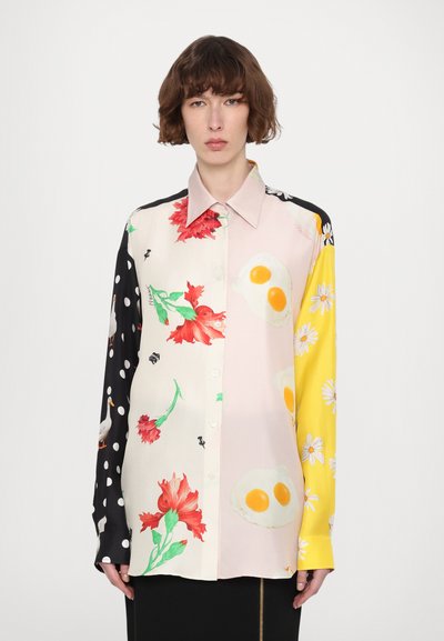 Langærmet skjorte med knapper, der har en blanding af blomster- og æggeprints, med sorte polka dots og en gul ærme. Fremstillet af glat stof.