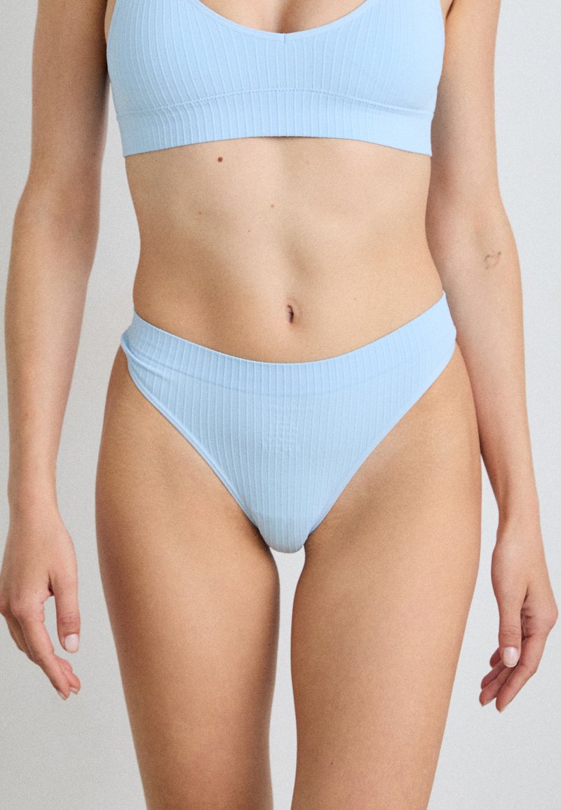 Ensemble de bikini rayé bleu clair avec un haut en bralette et un bas taille haute. Le matériau semble lisse avec une texture fine et des coutures subtiles.