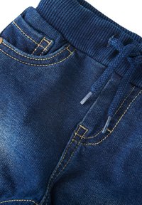 Denim joggers in diepblauw met een gestructureerde afwerking, voorzien van een elastische tailleband, koord en gele stiksels op de zakken.