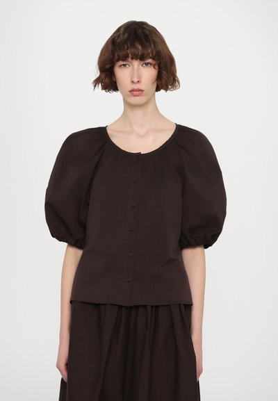 Bruine blouse met pofmouwen en een ronde halslijn, voorzien van een knoopsluiting aan de voorkant en zachte, gestructureerde stof.