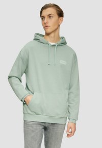 Felpa verde chiaro con cappuccio, tasca frontale, cordini e piccolo design ricamato sul petto. Materiale in cotone morbido, vestibilità comoda.