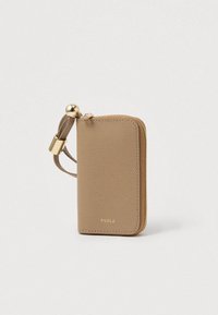 Kortholder i tanfarvet læder med struktureret finish, afrundede hjørner, guldfarvet hardware og lynlåslukning. Inkluderer et håndledsrem for nem brug.