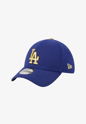 Casquette de baseball bleue en coton avec une visière incurvée. Présente un logo "LA" brodé en or sur le devant et un accent cousu sur le côté.