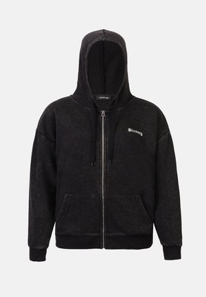 Sort hættezip-sweatshirt med en blød, tekstureret overflade, frontlommer og "Blessed" broderet i hvidt. Har en snoretrækshætte.