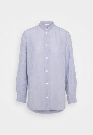 Jasnoniebieska i biała, cienko paskowana koszula z długim rękawem, z kołnierzykiem typu mandarynka i białymi guzikami z przodu, wisząca na jednolitym tle.