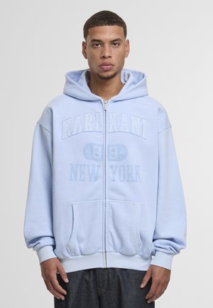 Svetlomodrá mikina s kapucňou na zips z mäkkej látky, s veľkým nápisom "KARL KANI" a "NEW YORK", predným vreckom a sťahovacou kapucňou.