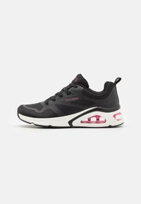 Scarpa sportiva nera con tessuto a rete, intersuola bianca, grande unità d'aria rosa e suola in gomma nera. Presenta lacci e logo Skechers.